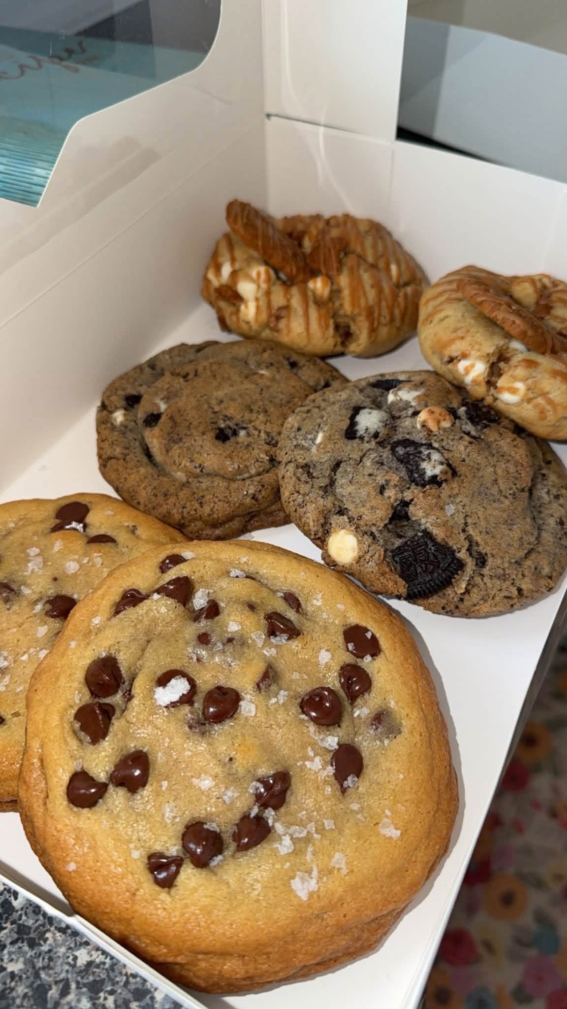 Box of assorted cookies including sea salt chocolate chip, cookies and cream, and pretzel treats